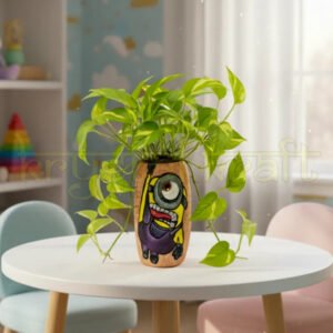 Hand-painted Hanging Minion design on a recycled Amul mini glass bottle with purple and yellow acrylics on a pink base — an eco-friendly mini vase or pen stand by Krystal Kraft.