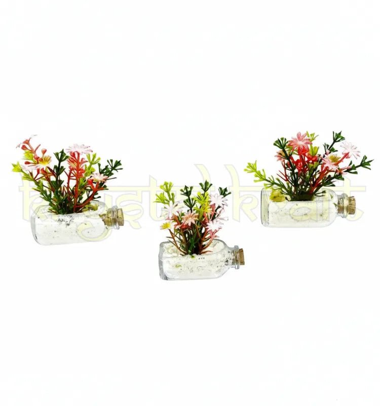 Beautiful magnetic mini glass bottle planters attached to a fridge surface, featuring green faux plants in clear repurposed glass bottles – stylish and sustainable decoration."